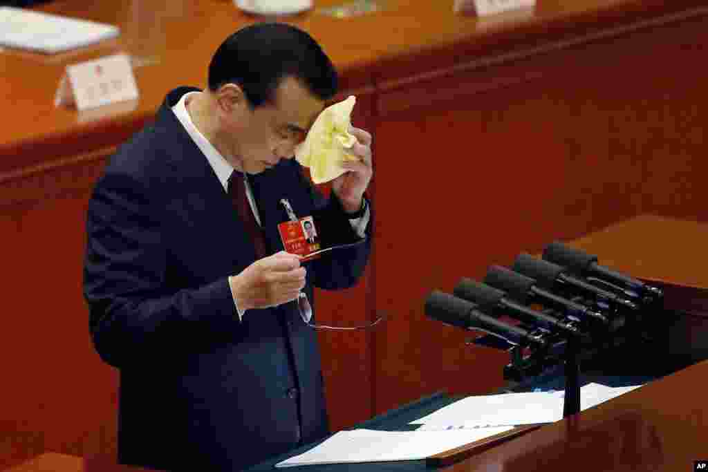 中国国务院总理李克强2018年3月5日在北京人民大会堂举行的全国人大会议开幕式上发表政府工作报告时擦脸,可能是擦汗。