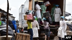 Des employés du ministère de la Santé chargent un camion après avoir vidé les magasins vendant de faux médicaments lors d'un raid au marché d'Adjamé à Abidjan, le 3 mai 2017.