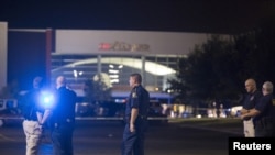 ARCHIVES - Les autorité de la ville de Lafayette se tiennent à l'extérieur d'une sale de cinéma ou a eu lieu une fusillade, en Louisiane, 23 juillet 2015. 