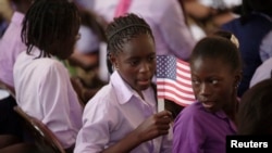 Une élève tenant un drapeau américain avant l'arrivée de la première dame des Etats-Unis, Michelle Obama, à l'école de filles Martin Luther King, à Dakar, 27 juin 2013. 