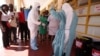A nurse is sprayed during a tour of one of the Ebola Centers in Harare, Zimbabwe, Sept. 23, 2014.