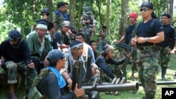In this undated file photo, Abu Sayyaf spokesman Abu Sabaya, right foreground, stands with militants in Basilan, the Philippines.