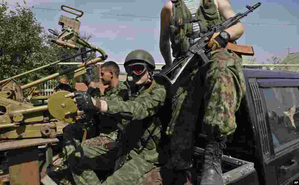 Pro-Russian rebels sit in their car with a heavy machine gun in Donetsk, eastern Ukraine, Sept. 7, 2014.