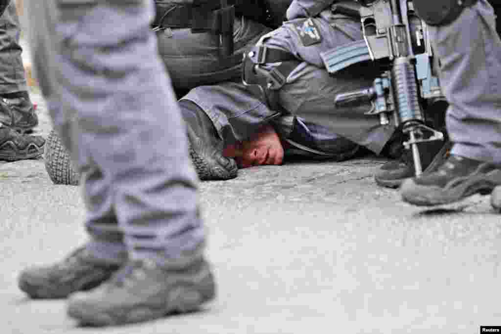Israeli policemen detain a Palestinian protestor during scuffles outside the compound housing al-Aqsa Mosque in Jerusalem's Old City. Israeli police closed the entrances to Jerusalem's most sensitive holy site after Palestinian suspects threw a firebomb at a police station.