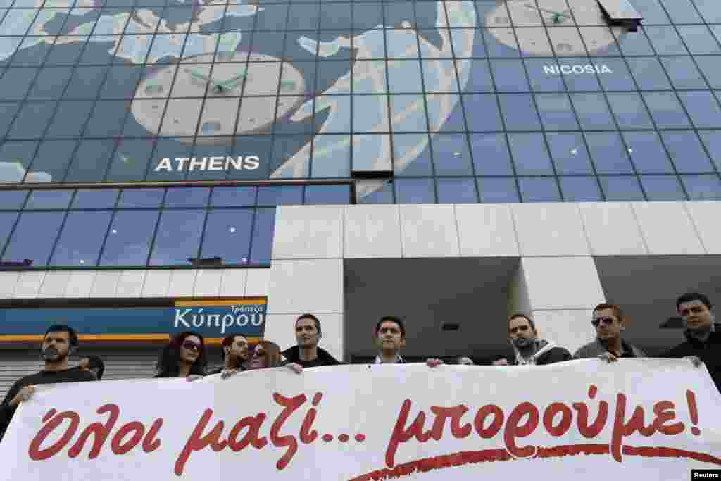 Employees of the Bank of Cyprus take part in a rally in solidarity with Cyprus outside the headquarters of the bank in Athens, Greece, March 20, 2013.
