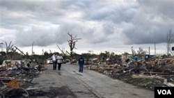 Warga berjalan di sekitar rumah-rumah yang hancur akibat badai hebat dan angin topan tornado di Birmingham , Alabama, Kamis (28/4).
