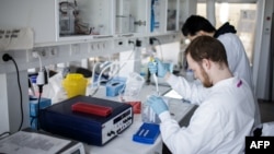 Des chercheurs travaillent sur un vaccin contre le nouveau coronavirus COVID-19 au laboratoire de recherche de l'Université de Copenhague à Copenhague, au Danemark, le 23 mars 2020.