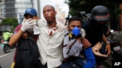 Des paramédicaux portent secours à un homme blessé lors des affrontements entre manifestants et forces de l'ordre à Caracas, Venezuela, le 20 avril 2017.