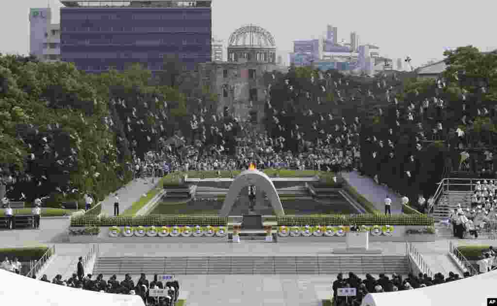 Merpati terbang di monumen yang dipersembahkan untuk para korban pengeboman di Hiroshima Peace Memorial Park dalam upacara peringatan 68 tahun serangan itu (6/8). (AP/Shizuo Kambayashi)