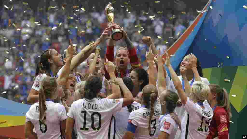 Les joueuses de l'équipe nationale féminine des États-Unis célèbrent, brandissant le trophée, après avoir battu le Japon 5-2 lors de la finale de football de la Coupe du Monde Féminine de la FIFA à Vancouver, Colombie-Britannique, le 5 juillet 2015.