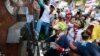 Anti-government protesters break the police sign outside police headquarters during a rally in Bangkok, Thailand, Jan. 22, 2014. 