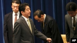 日本首相安倍晋三离开在东京举行的记者会。（2013年12月9日）