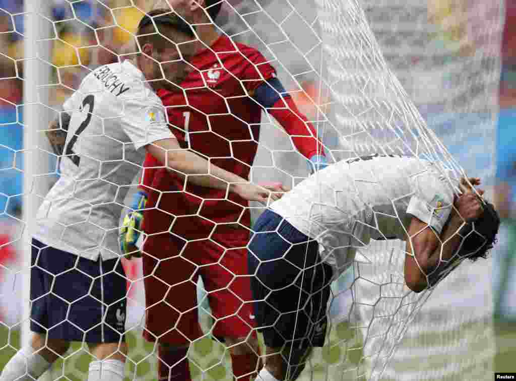 Pemain Perancis Raphael Varane beristirahat di gawang setelah cedera dalam pertandingan melawan Nigeria, di stadion nasional di Brasilia, 30 Juni 2014.