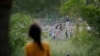 La venezolana Nathaly, de 13 años, observa a agentes de la Patrulla Fronteriza de EEUU devuelven a un grupo de migrantes a México, mientras ella y su familia intentan obtener una cita en la app CBP One desde un campamento improvisado en Matamoros, México, 21 de junio de 2023.