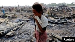 Seorang perempuan berjalan di antara puing-puing setelah kebakaran di kamp penampungan pengungsi Muslim Rohingya, negara bagian Rakhine barat dekat Sittwe, Myanmar, 3 Mei 2016. (Foto: dok).