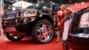 Promotional models chat next to a luxury tuning Hummer H2 during the IXth International auto show "Motor Show 2005" in Moscow, 24 August 2005. (file photo)