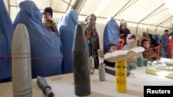 Afghan refugees family returning from Pakistan look at explosives and mines during an awareness program at the United Nations High Commissioner for Refugees registration center in Mommand Dara district in Jalalabad province, November 20, 2012.