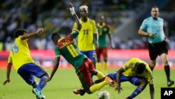Le Gabonais Serge Ngouali, à gauche, et André Biyogo Poko, à droite, bataillent autour du ballon avec le Camerounais Edgar Salli lors du match du groupe A de la Coupe d’Afrique des nations entre le Gabon et le Cameroun au stade de l’Amitié, à Libreville,