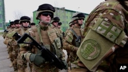 FILE - Georgian troops march during a sending off ceremony before leaving for Afghanistan in Tbilisi, Georgia.