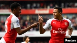 Alexis Sanchez, à droite, et Alex Iwobi jubilent d’Arsenal après le premier but de leur équipe lors d’un mach de la Premier League anglaise contre Watford – au stade Emirates, 2 avril 2016. 