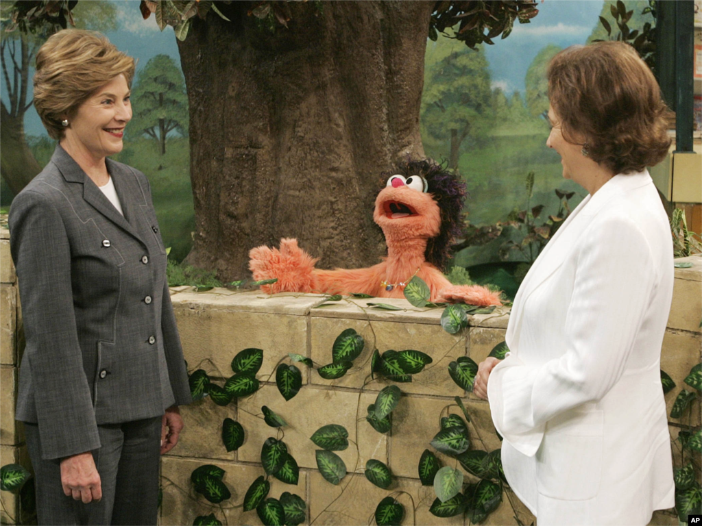 Ibu Negara AS Laura Bush (kiri) dan Suzanne Mubarak, istri Presiden Mesir Hosni Mubarak (kanan) berbincang-bincang dengan Khokha (tengah) seorang karakter dari "Alam Simsim," Sesame Street versi Mesir, pada 23 Mei 2005 di Giza, Mesir.