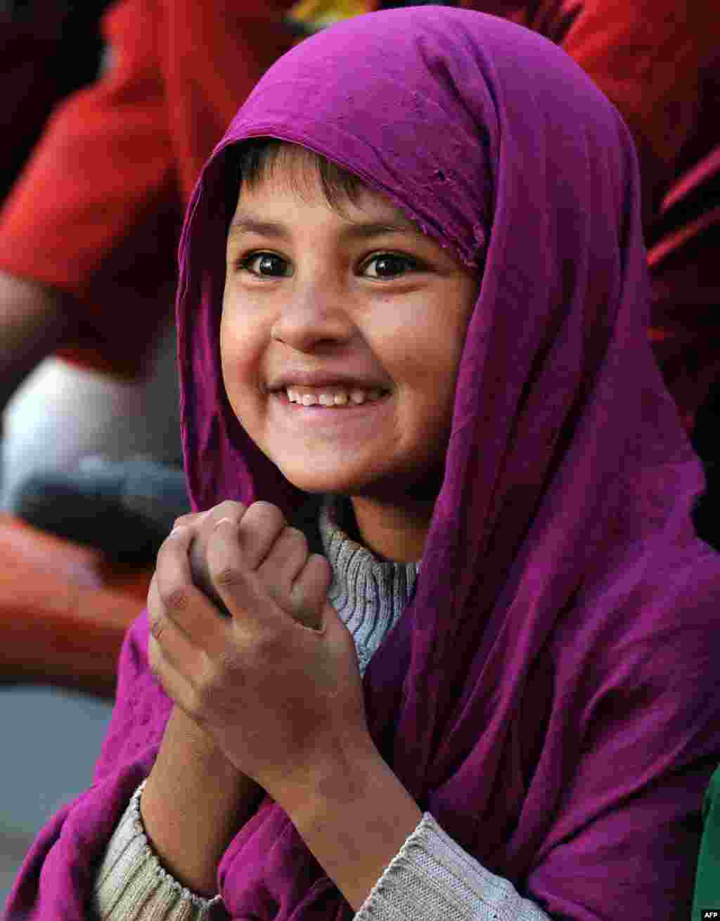 An Afghan child looks on as performers from The Mobile Mini Circus for Children (MMCC) take part in a circus show in Kabul.