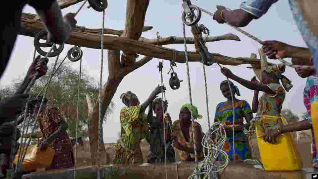 Des femmes tirent de l'eau dans un puits dans le village de Kiral, au Sénégal, le 1 mai 2012.
