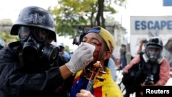 Seorang demonstran yang luka-luka dibantu oleh petuas keamanan saat protes menentang pemerintahan Presiden Venezuela Nicolas Maduro di Caracas, Venezuela, 22 Juli 2017.