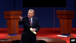 This Oct. 3, 2012 file photo shows moderator Jim Lehrer addressing the audience before the first presidential debate at the University of Denver in Denver. 