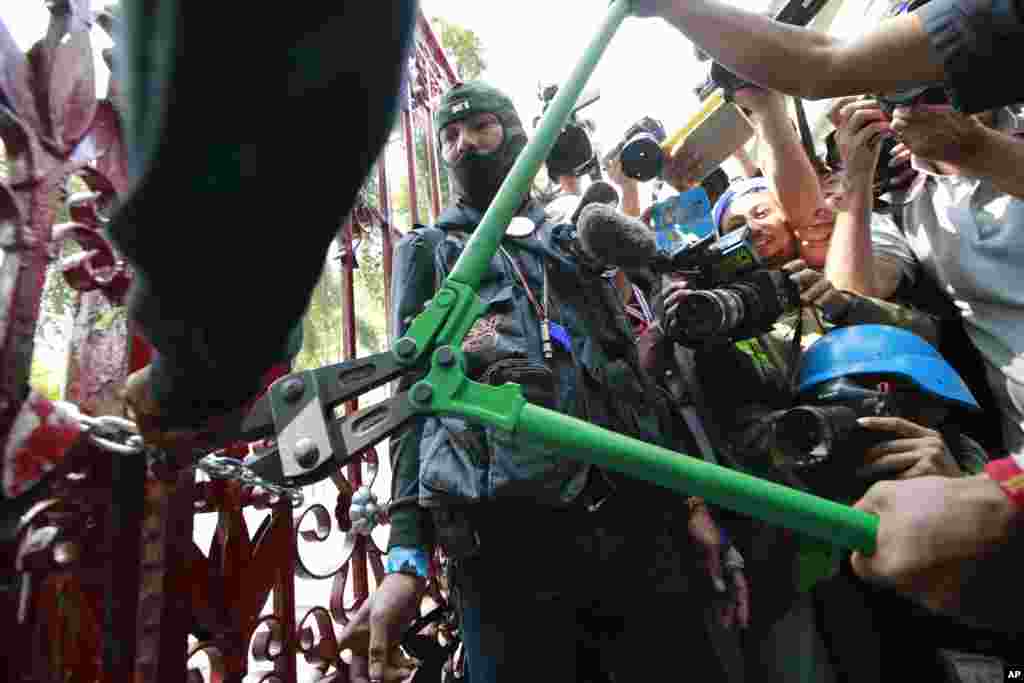 Demonstran anti pemerintah merusak pintu markas besar polisi ketika demo di Bangkok, 22 Januari 2014.