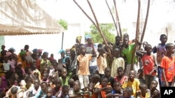 African children watch a play on malaria prevention at the Mbosse health clinic.