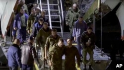 FILE - Sekelompok tahanan perang Rusia meninggalkan pesawat militer Rusia setelah mereka dibebaskan, di lokasi yang tidak ditentukan di Rusia, 22 September 2022. (Layanan Pers Kementerian Pertahanan Rusia via AP)