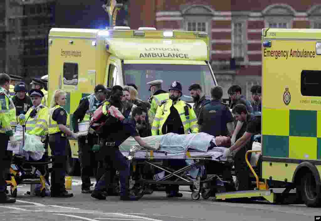 Emergency services transport an injured person to an ambulance, close to the Houses of Parliament in London, March 22, 2017.