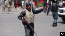 Un policía afgano hace guardia después de una explosión suicida cerca de la sede policial en Kabul, Afghanistán, el miércoles, 7 de agosto de 2019.