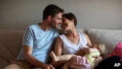 Clara Massons alimenta a su hijo Jaume de dos años junto a su esposo Toni, en su casa en Barcelona, España. 