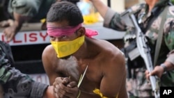 Suspected Muslim rebels whom the military said were either captured or surrendered, arrive at a police station for processing in Zamboanga City, southern Philippines, Sept. 26, 2013.