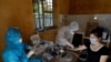 Medical specialists collect blood sample from a woman who has returned after travelling to Da Nang, at a rapid testing center for COVID-19 outside Hanoi, Vietnam, July 30, 2020.