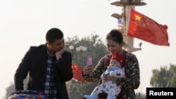 一对中国父母在北京天安门拍照留念。（2015年11月2日）
