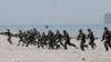 FILE - U.S. and Philippine marines storm the beach to simulate a raid during the joint U.S.-Philippines military exercise at the Naval Training Exercise Command in Zambales province, northwest of Manila, May 9, 2014.