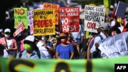 Integrantes de organizaciones y movimientos sociales salvadoreños participan en una marcha de protesta contra el gobierno de Nayib Bukele en San Salvador el 22 de enero de 2020.