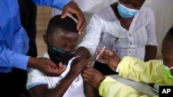 A boy winces as he receives his COVID-19 vaccine in Diepsloot Township, near Johannesburg, South Africa, Oct. 21, 2021.