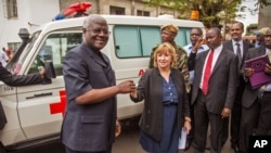 FILE - Sierra Leone President Ernest Bai Koroma, left, is handed the keys to an ambulance by U.S. Embassy representative Kathleen FitzGibbon, center, one of five ambulances donated by the U.S. to help combat the Ebola virus in Freetown, Sierra Leone.