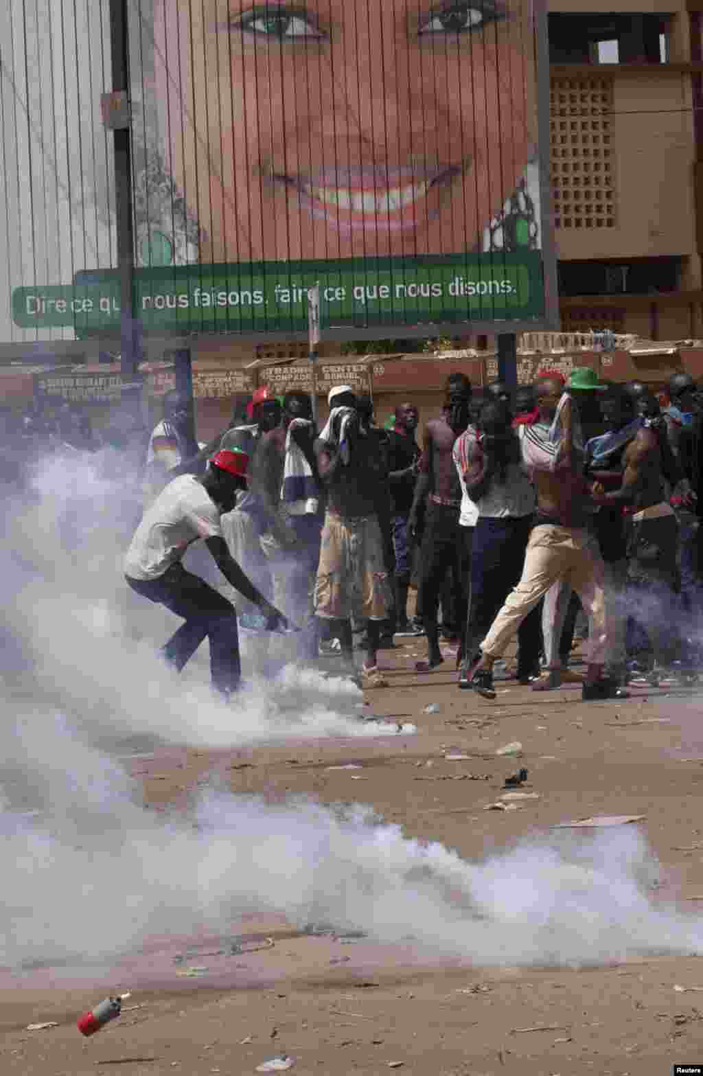 Des manifestants tentent de se couvrir du gaz lacrymogène que la police a lancé lors d’une manifestation contre la révision constitutionnelle à Ouagadougou, Burkina Faso, le 28 octobre 2014.