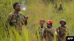 Un combattant de la Force patriotique de résistance pour la milice de l'Ituri (FRPI) fume, 28 juillet 2006, près de Tchei, dans le sud de l'Ituri. L'ONU fait pression pour une reddition complète de la milice dans la région pour garantir des élections sans heurts. PHOTO AFP / LION