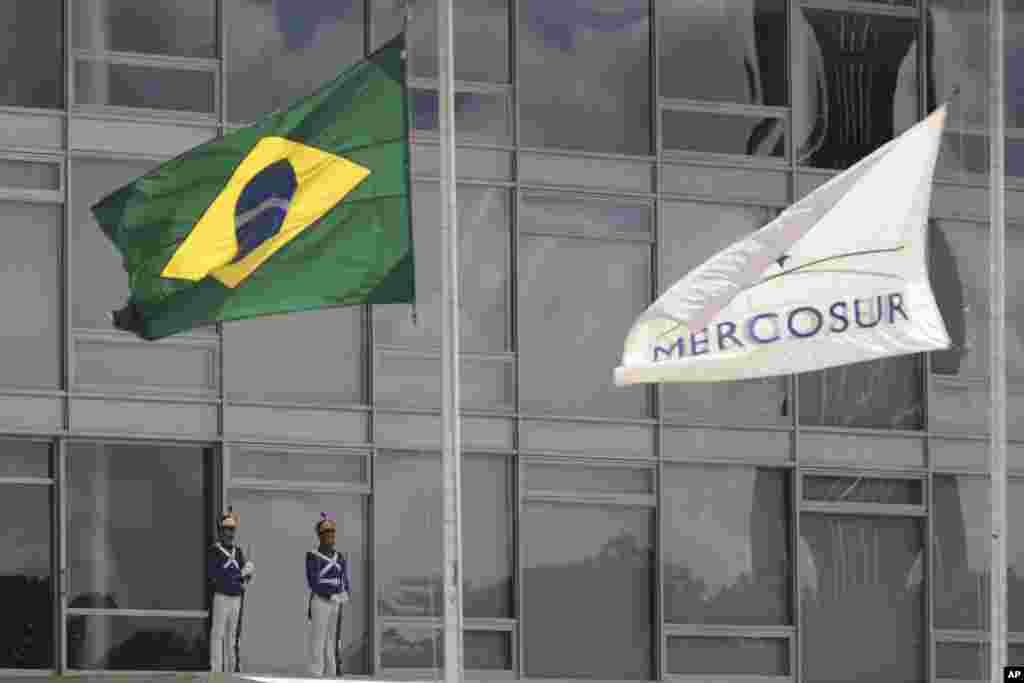 The Brazilian national flag along with a MERCOSUR banner fly at half-staff to honor plane crash victims, outside the Planalto Presidential Palace in Brasilia, Brazil. The Brazilian government declared three days of mourning. 