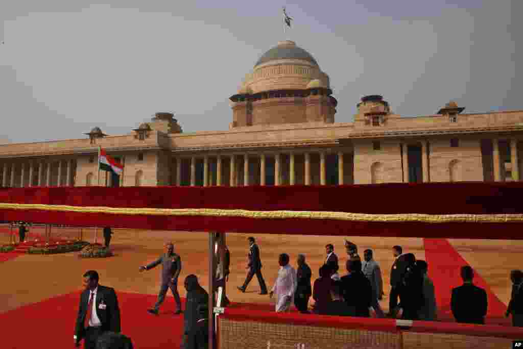 Sri Lanka’s President Maithripala Sirisena (center in white) walks on the red carpet with Indian President Pranab Mukherjee after inspecting a ceremonial reception at the Indian Presidential Palace in New Dehli, Feb. 16, 2015.