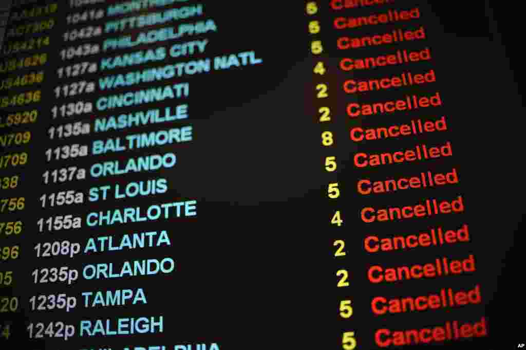 Daftar pembatalan penerbangan di Bandara Internasional Bradley akibat badai salju di Windsor Locks, Connecticut (27/1). (AP/Jessica Hill)