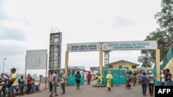 FILE - People walk by the entrance to the Yaounde General Hospital in Yaounde, March 6, 2020. Healthcare workers are marking World Hepatitis Day on July 28, 2020, to raise awareness of the virus.