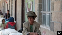file - A boy waits for food supplies provided by the World Food Program at a school in Sana'a, Yemen, Aug. 25, 2019.
