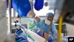 Personal médico atiende a un paciente con COVID-19 en la unidad de cuidados intensivos del Hospital Universitario de Estrasburgo, Francia, el jueves 13 de enero de 2022. (Foto AP/Jean-Francois Badias)